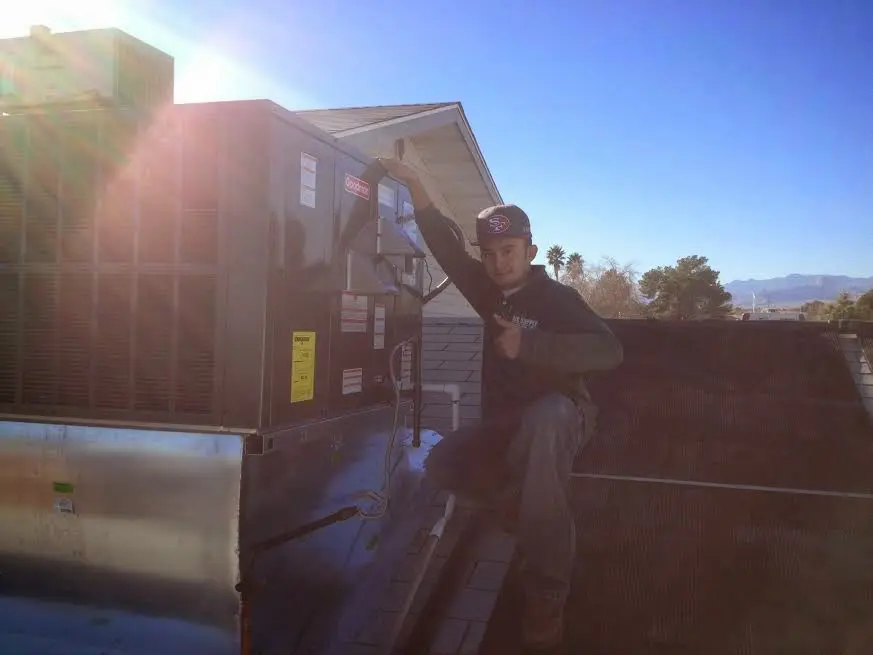 HVAC technician performing Air Duct Cleaning on a rooftop unit in Hartford